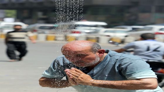 An Iraqi man cools his head under a showers set-up along a street in the capital Baghdad as temperature soar during the Muslim fasting month of Ramadan on July 15, 2013. Throughout the month, devout Muslims must abstain from food and drink from dawn until sunset when they break the fast with the Iftar meal. AFP PHOTO/AHMAD AL-RUBAYE