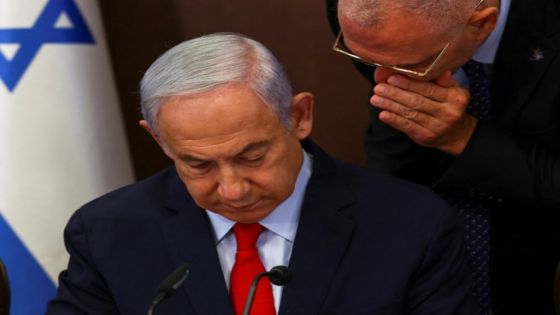 Israeli Prime Minister Benjamin Netanyahu reads from some papers as he convenes a cabinet meeting at the Prime Minister's office in Jerusalem, May 7, 2023. REUTERS/Ronen Zvulun/Pool