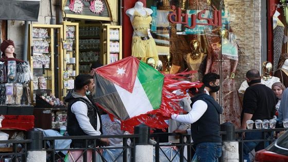 People buy a kite designed as a national flag from a shop in Jordan's capital Amman, on April 5, 2021, after a rare security operation took place in the country. - Jordan's Prince Hamzah, accused by the government of a "wicked" plot against his elder half-brother King Abdullah II, insisted he will not obey orders restricting his movement. The government has accused him of involvement in a seditious conspiracy to "destabilise the kingdom's security", placed him under house arrest and detained at least 16 more people. (Photo by Khalil MAZRAAWI / AFP) (Photo by KHALIL MAZRAAWI/AFP via Getty Images)