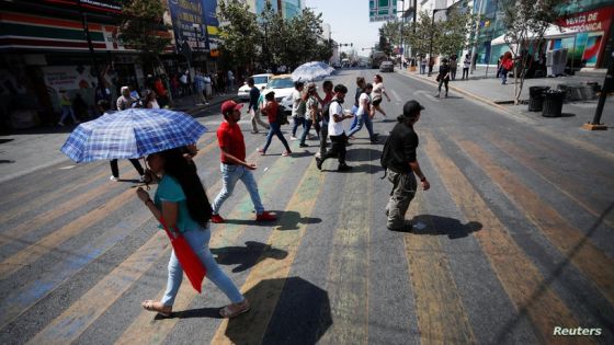 People walk across a street as temperatures rise during an unusual heat wave, in Monterrey, Mexico June 14, 2023. REUTERS/Daniel Becerril